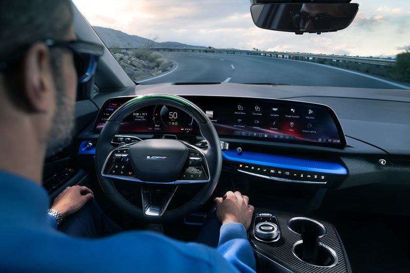 Front View of the 2026 OPTIQ-V Driving Through the Dusk Utilizing its Headlights | Ben Mynatt Cadillac in Concord NC